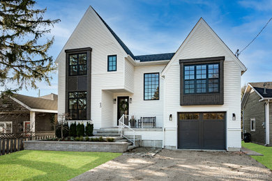 Imagen de fachada de casa blanca de estilo americano de dos plantas con tejado de teja de madera