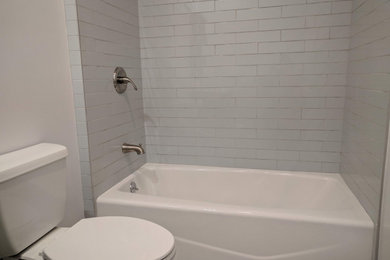 ロサンゼルスにあるお手頃価格のコンテンポラリースタイルのおしゃれな浴室 (分離型トイレ、青いタイル、セラミックタイル、白い壁、セラミックタイルの床、シャワーカーテン、洗面台1つ) の写真