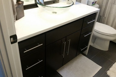 Small modern bathroom in Boston with flat-panel cabinets and quartzite benchtops.