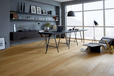 Großes Modernes Arbeitszimmer mit braunem Holzboden und braunem Boden