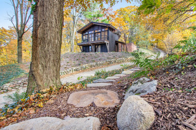 Mountain style black two-story wood house exterior photo in Grand Rapids