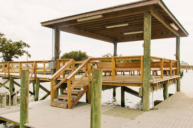 Design ideas for a large beach style backyard deck in New Orleans with with dock.