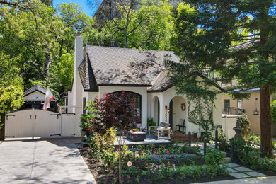 Mid-sized elegant two-story stucco house exterior photo in Sacramento with a clipped gable roof, a shingle roof and a brown roof