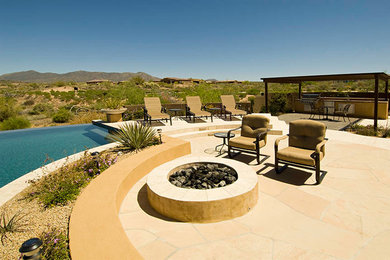 Large southwest backyard stone and custom-shaped infinity pool photo in Phoenix