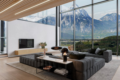 Idee per un grande soggiorno moderno stile loft con TV a parete, carta da parati, parquet chiaro e camino sospeso