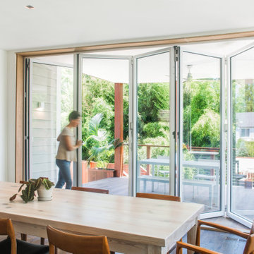 Indoor–Outdoor Flow from Kitchen to Covered Deck Through NanaWall Glass Doors