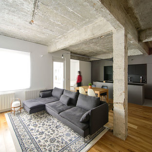 Ejemplo de salón abierto, industrial, con suelo de madera en tonos medios, paredes blancas y suelo marrón