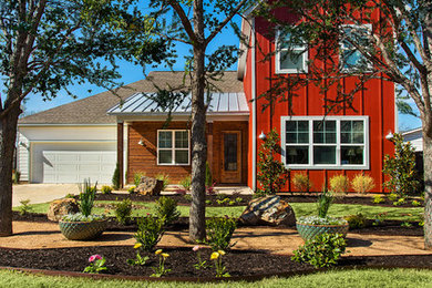 Inspiration for a mid-sized country two-storey red house exterior in Dallas with mixed siding and a mixed roof.
