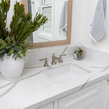 Double undermounted vanity sinks sit in a Calcutta Belleza white quartz countert