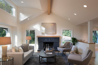 This is an example of a mid-sized transitional formal open concept living room in San Francisco with white walls, a standard fireplace, a stone fireplace surround, no tv, brown floor and light hardwood floors.