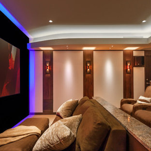 Idées déco pour une grande salle de cinéma contemporaine fermée avec un mur beige, moquette, un écran de projection et un sol beige.