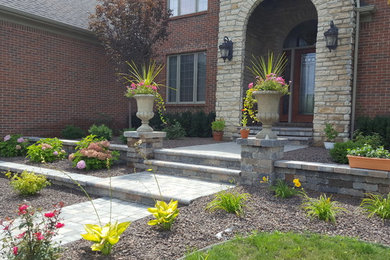 Design ideas for a traditional front yard verandah in Detroit with brick pavers.