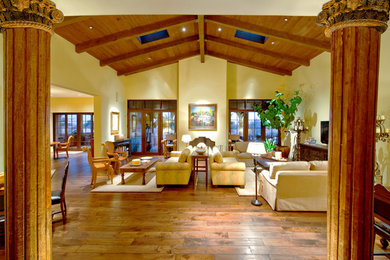Inspiration for a huge timeless open concept dark wood floor living room remodel in Phoenix with yellow walls, a standard fireplace, a plaster fireplace and a wall-mounted tv
