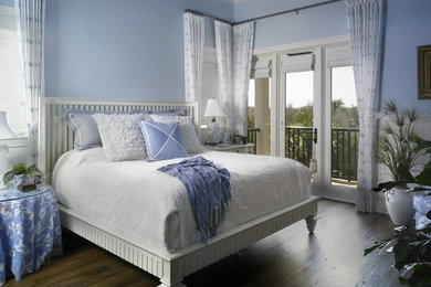 Inspiration for a mid-sized transitional guest medium tone wood floor bedroom remodel in Miami with blue walls