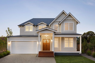 Mid-sized transitional two-storey grey house exterior in Melbourne with wood siding, a gable roof and a metal roof.