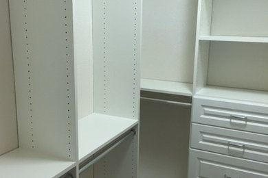 Example of a mid-sized transitional gender-neutral carpeted walk-in closet design in Austin with raised-panel cabinets and white cabinets