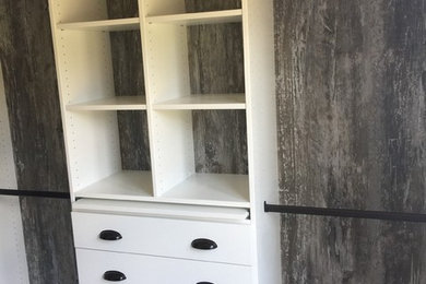 Photo of a mid-sized modern walk-in wardrobe in Richmond with flat-panel cabinets, white cabinets and carpet.