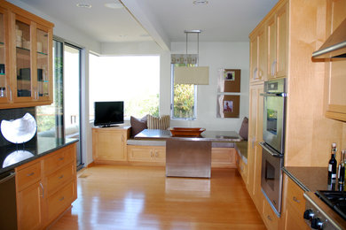 Eat-in kitchen - large contemporary light wood floor eat-in kitchen idea in Orange County with a drop-in sink, light wood cabinets, granite countertops, multicolored backsplash, stone slab backsplash, stainless steel appliances and an island