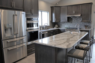 Large transitional l-shaped porcelain tile and gray floor eat-in kitchen photo in New York with an undermount sink, recessed-panel cabinets, brown cabinets, quartz countertops, multicolored backsplash, mosaic tile backsplash, stainless steel appliances and an island