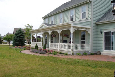 Ornate front porch idea in Milwaukee with decking and a roof extension