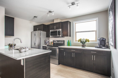 Mid-sized minimalist u-shaped light wood floor eat-in kitchen photo in Other with an undermount sink, shaker cabinets, dark wood cabinets, quartzite countertops, stainless steel appliances and an island