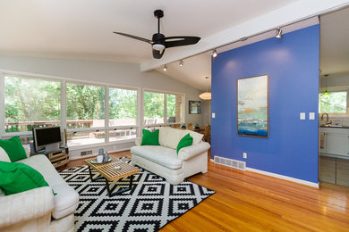 Mid-sized transitional open concept medium tone wood floor and brown floor living room photo in Kansas City with gray walls, no fireplace and a tv stand