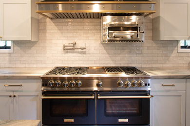Foto på ett stort vintage flerfärgad u-kök, med en undermonterad diskho, skåp i shakerstil, grå skåp, bänkskiva i kvartsit, vitt stänkskydd, stänkskydd i keramik, svarta vitvaror, mellanmörkt trägolv, en köksö och brunt golv
