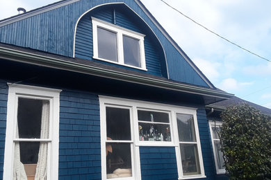 Large traditional blue two-story wood and shingle exterior home idea with a shingle roof and a black roof