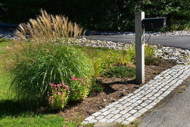 This is an example of a mid-sized farmhouse full sun backyard stone driveway in Boston.