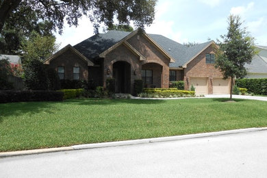 Mid-sized transitional two-storey brick red exterior in Orlando.