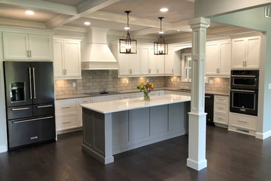Design ideas for a large traditional l-shaped eat-in kitchen in Other with an undermount sink, shaker cabinets, white cabinets, quartzite benchtops, grey splashback, brick splashback, stainless steel appliances, dark hardwood floors, with island and grey benchtop.