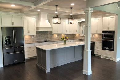 Example of a large classic l-shaped dark wood floor eat-in kitchen design in Other with an undermount sink, shaker cabinets, white cabinets, quartzite countertops, gray backsplash, brick backsplash, stainless steel appliances, an island and gray countertops