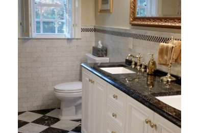 Tub/shower combo - mid-sized traditional white tile and stone tile marble floor tub/shower combo idea in DC Metro with an undermount sink, white cabinets, granite countertops and a two-piece toilet