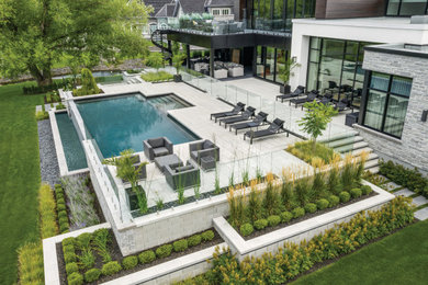 Large minimalist backyard concrete and rectangular lap pool landscaping photo in Montreal