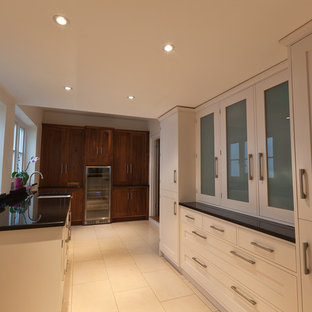 Large contemporary kitchen pantry ideas - Inspiration for a large contemporary u-shaped porcelain floor kitchen pantry remodel in Kent with a farmhouse sink, shaker cabinets, white cabinets, granite countertops, stainless steel appliances and an island