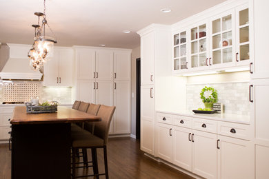Mid-sized transitional u-shaped medium tone wood floor and brown floor kitchen photo in Omaha with shaker cabinets, white cabinets, granite countertops, white backsplash and paneled appliances