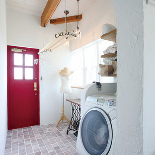 Design ideas for a mediterranean utility room in Other with white walls and brown floors.