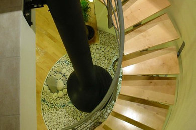 Idee per un'ampia scala a chiocciola minimal con pedata in legno verniciato, nessuna alzata e parapetto in metallo