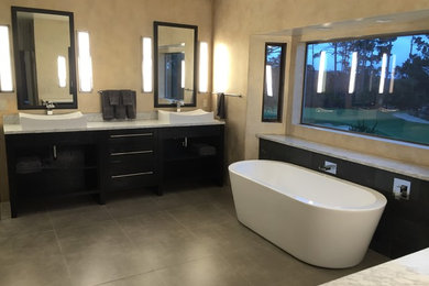 Design ideas for a large contemporary ensuite bathroom in San Francisco with shaker cabinets, dark wood cabinets, a freestanding bath, a corner shower, a wall mounted toilet, grey tiles, porcelain tiles, multi-coloured walls, porcelain flooring, a vessel sink and marble worktops.