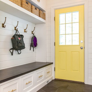 ボストンの片開きドアトランジショナルスタイルのおしゃれなマッドルーム (白い壁、黄色いドア、グレーの床) の写真