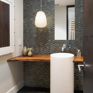 Inspiration for a contemporary gray tile gray floor powder room remodel in San Diego with gray walls, a pedestal sink, wood countertops and brown countertops