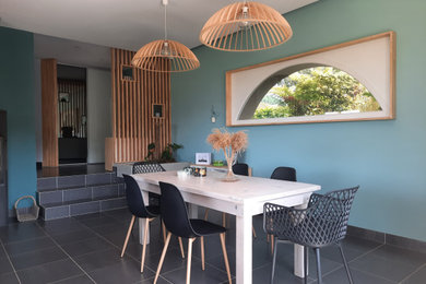 Exemple d'une salle à manger ouverte sur le salon tendance de taille moyenne avec un mur bleu, un sol en carrelage de céramique, un poêle à bois et un sol gris.