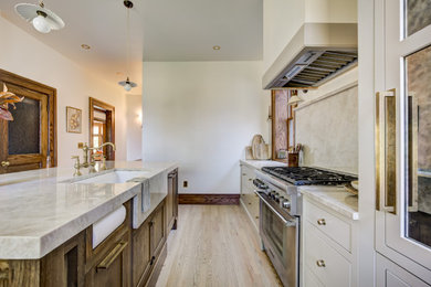 Inspiration for a mid-sized timeless galley medium tone wood floor and brown floor eat-in kitchen remodel in Detroit with an undermount sink, flat-panel cabinets, dark wood cabinets, quartzite countertops, multicolored backsplash, quartz backsplash, paneled appliances, an island and multicolored countertops