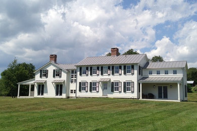 Example of a large cottage white two-story vinyl exterior home design in New York with a metal roof