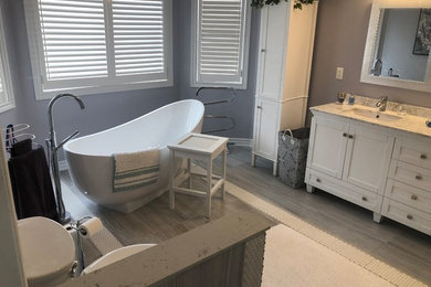 Large minimalist master white tile and ceramic tile vinyl floor, gray floor, double-sink and vaulted ceiling bathroom photo in Toronto with recessed-panel cabinets, white cabinets, marble countertops, a freestanding vanity, a one-piece toilet, gray walls, an integrated sink and a hinged shower door