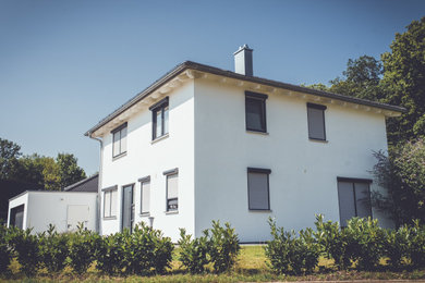 Zweistöckiges Modernes Einfamilienhaus mit Putzfassade, weißer Fassadenfarbe, Ziegeldach und grauem Dach in Stuttgart
