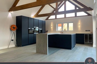 Inspiration for a large contemporary l-shaped open plan kitchen in Other with a built-in sink, flat-panel cabinets, blue cabinets, quartz worktops, white splashback, stainless steel appliances, an island and white worktops.