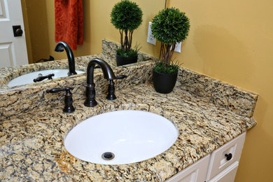 Example of a small farmhouse bathroom design in Louisville with an undermount sink, white cabinets, granite countertops and yellow walls
