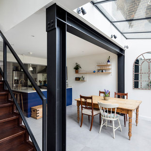 Einzeilige, Große Klassische Küche mit Vorratsschrank, Einbauwaschbecken, Schrankfronten mit vertiefter Füllung, blauen Schränken, Granit-Arbeitsplatte, Rückwand aus Spiegelfliesen, Küchengeräten aus Edelstahl, Keramikboden, Kücheninsel und grauem Boden in London