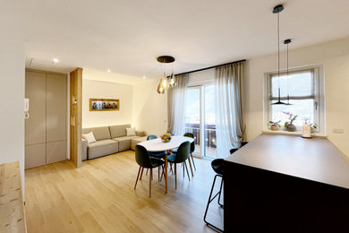 Esempio di un soggiorno minimal di medie dimensioni e aperto con pareti bianche, pavimento in laminato e TV a parete